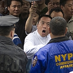 NYPD officers confront an angry mob in Flushing, New York, making at least two arrests of individuals assaulting Falun Gong adherents.