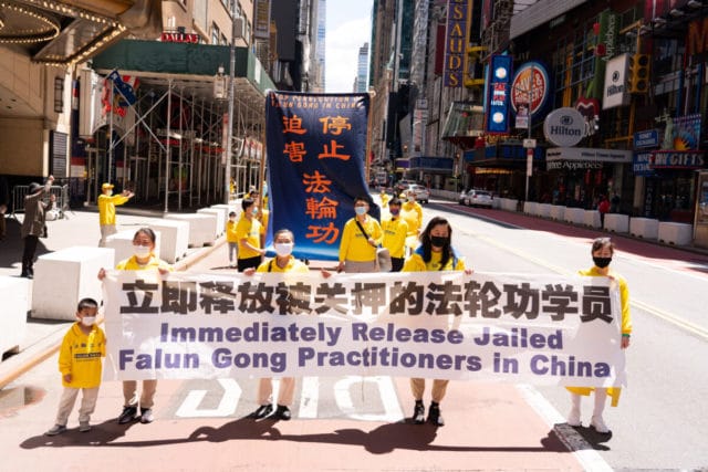 Falun Gong practitioners holding banners in a parade to protest the ongoing persecution of the group in China. (Larry Dai/The Epoch Times)