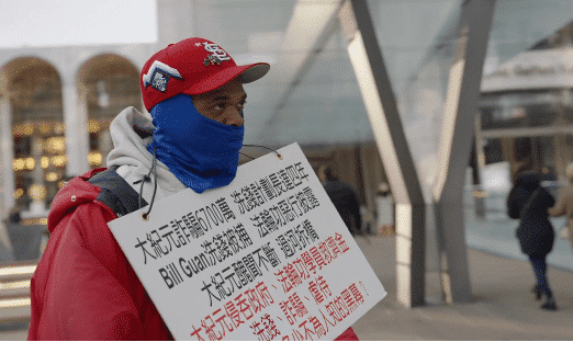 Man who doesn’t speak Chinese holds a Chinese sign. His comments indicated he may have believed he was protesting against “Communist” China, not its critics.