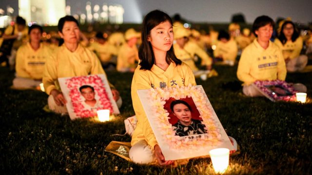 Falun Gong practitioners take part in a candlelight vigil remembering victims of the 22-year-long persecution in China at the Washington Monument on July 16, 2021. (Samira Bouaou/The Epoch Times).