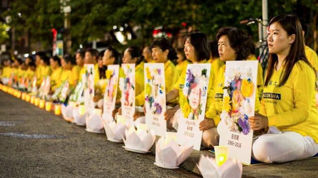 Falun Gong practitioners hold a candlelight vigil in front of the Chinese Consulate in Toronto on July 13, 2019, holding photos of fellow adherents who had died as a result of persecution in China.
