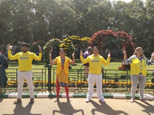 Falun Dafa practitioners meditate next to their display and booth at the 213th annual flower show in Bangalore, India during India's Republic Day celebrations on January 26, 2023.