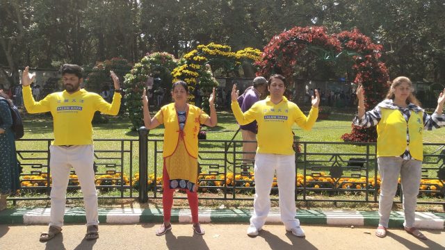 Falun Dafa practitioners meditate next to their display and booth at the 213th annual flower show in Bangalore, India during India's Republic Day celebrations on January 26, 2023.