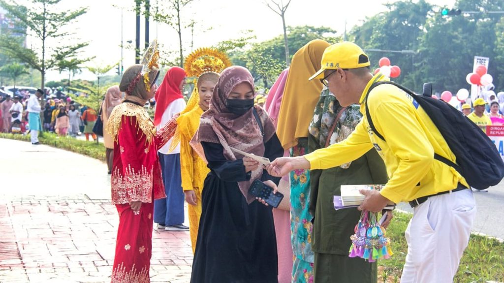 Falun Gong practitioner hands out flyers to attendees at Indonesia’s 78th Independence Day parade held in Batam city, on the Riau Islands.