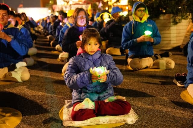 Falun Gong practitioners hold a candlelight vigil in front of the Chinese Consulate in New York City on April 21, 2024. (Larry Dye/The Epoch Times)