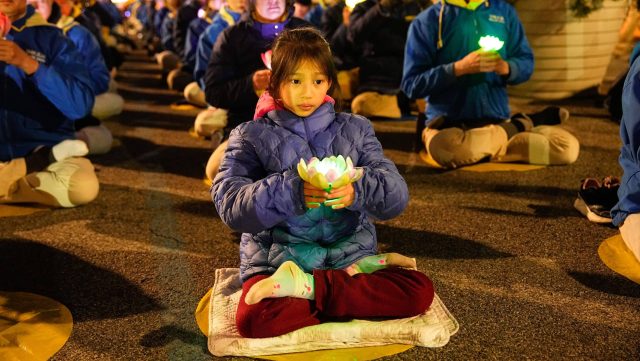 Falun Gong practitioners hold a candlelight vigil in front of the Chinese Consulate in New York City on April 21, 2024. (Larry Dye/The Epoch Times)