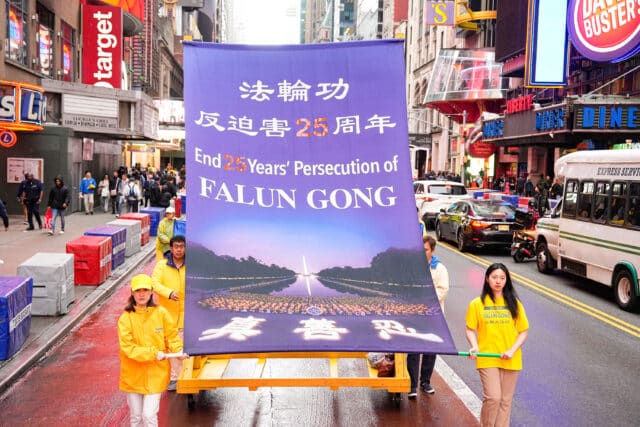 Falun Gong practitioners carry a banner in a May 13, 2024
procession in New York commemorating the anniversary of Falun Gong’s
introduction to the public. (Source: Tuidang Center)