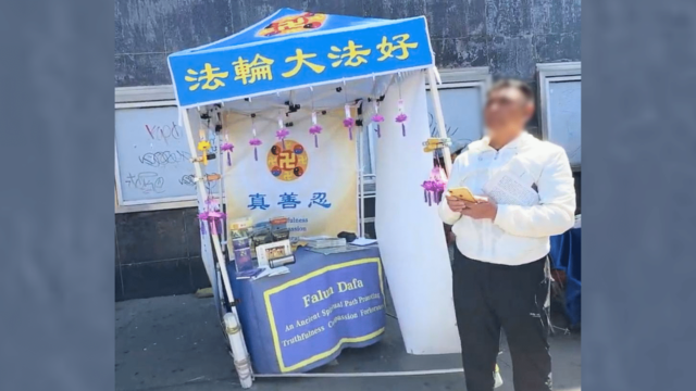 A Falun Gong practitioner stands in apparent shock after an assailant fled the scene, leaving the informational booth visibly dislodged and disordered. The table had been shifted by a series of forceful kicks, in what observers identify as a potential act of transnational repression against overseas Falun Gong practitioners. (Photo: The Global Tuidang Center)
