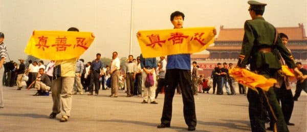 Falun Gong practitioners hold up banners bearing Chinese characters: Truthfulness, Compassion, and Forbearance, at Tiananmen Square in Beijing.