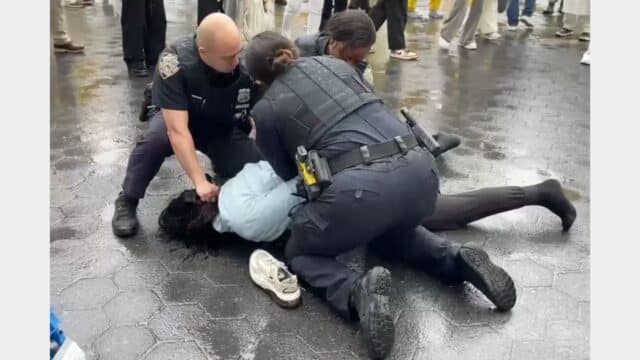 NYPD officers detain a man who disrupted a World Falun Dafa Day celebration at Union Square in Manhattan on May 9, 2026.(NTDTV.com)